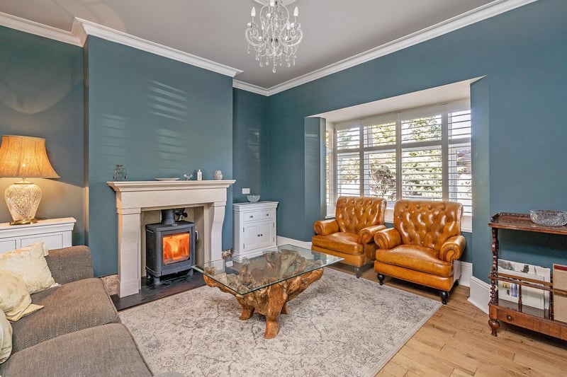 The beautiful formal lounge has a walk in bay window, wood flooring and feature fireplace with log burner, a serene room to relax and read a book.