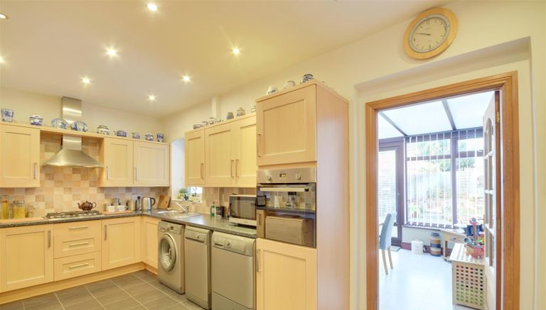 A spacious kitchen which leads into the conservatory