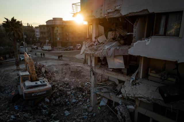 Men walk down a street amid rubble from destroyed buildings on February 20, 2023 in Hatay, Turkey