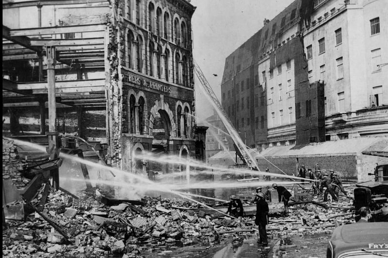 Firefighters work tirelessly to extinguish John Wright’s Printing Works after the Good Friday Air Raid on February 11, 1941. Across the road, the newly-built Electricity House survived the raid thanks partly to the netting draped over the building to make it hard for german bombers to spot.