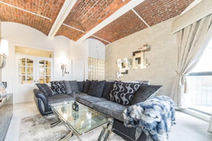 The property has a large living room, with exposed brick ceiling and views of the docks.