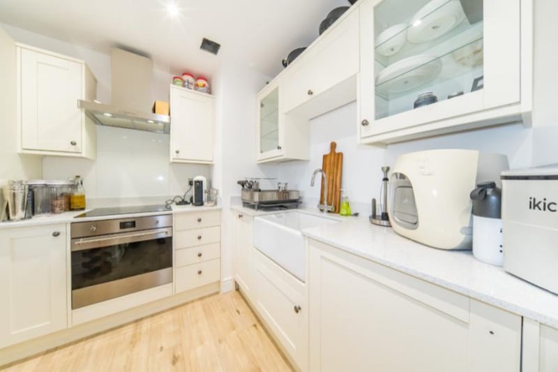 The kitchen has modern fixtures and white cupboards. 