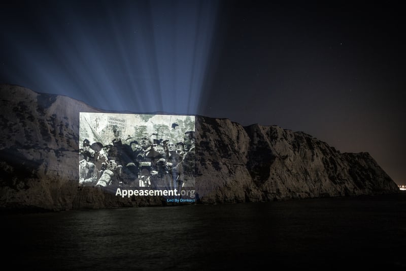 The group made another projection on the White Cliffs of Dover in May 2020, that time comparing then Prime Minister Boris Johnson’s response to the coronavirus crisis to Neville Chamberlain’s “peace for our time” moment. It included a mock-up of the then PM holding a scrap of paper saying “Highest death toll in Europe”.