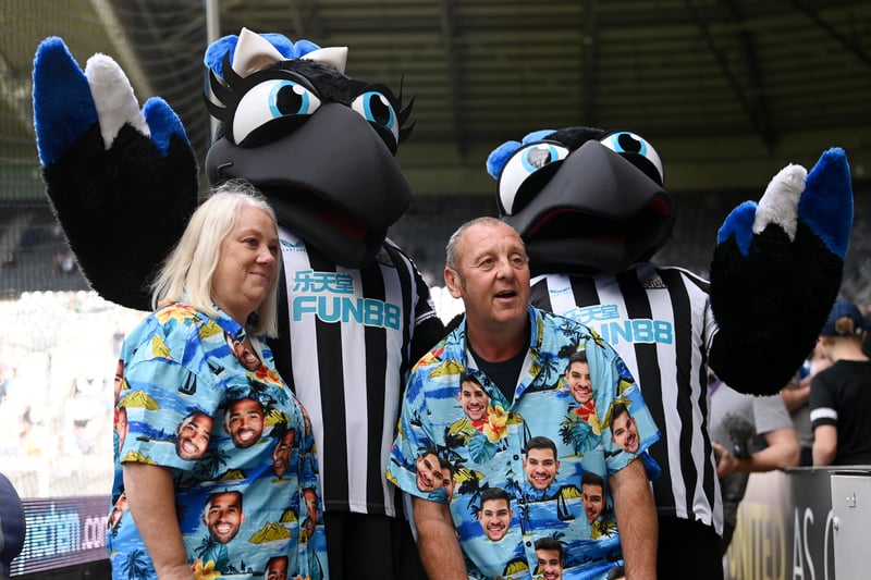Fans of Newcastle United pose for a photograph with match mascots prior to kick off of the Premier League match between Newcastle United and Manchester City at St. James Park on August 21, 2022