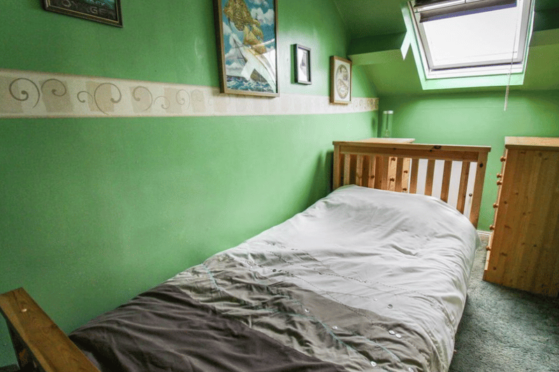 The second, bigger bedroom is seen here, featuring a window overhead for good morning views