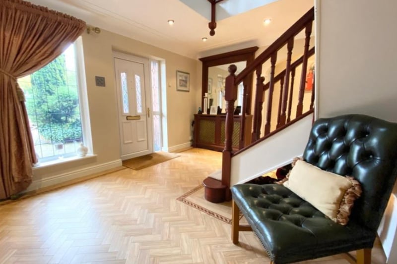 It has parquet flooring and a dark wooden staircase.