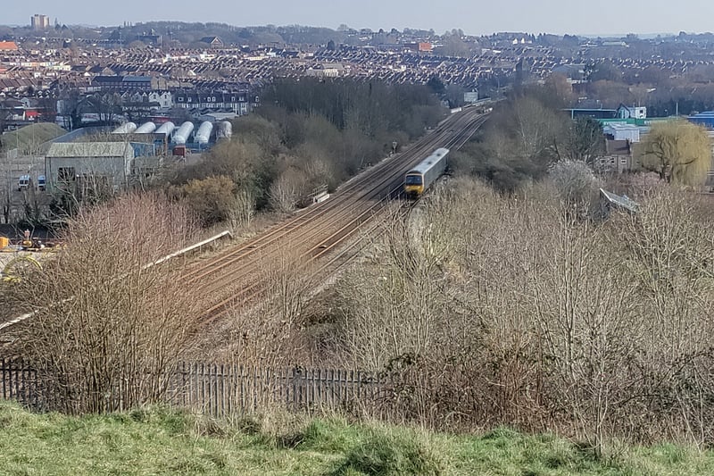 A train on the railway line toward Bristol Parkway passes as we look from the top of Narroways Nature Reserve toward the north of the city.