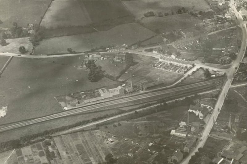 This aerial image shows a small section of Warmley Railway Station on the right hand side of the A420 London Road. The station, opened in 1869 and closed in 1966, now has a cafe popular with cyclists and walkers using the old Bath Green Park to Bristol railway line.