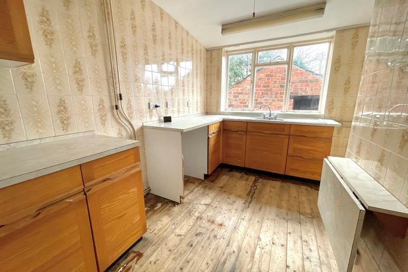 The kitchen needs a complete overhaul and looks out into the back garden.
