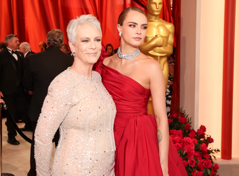 Jamie Lee Curtis and Cara Delevingne. Delevingne wore an off the shoulder red gown by Elie Saab while Lee Curtis wore a striking silver dress.