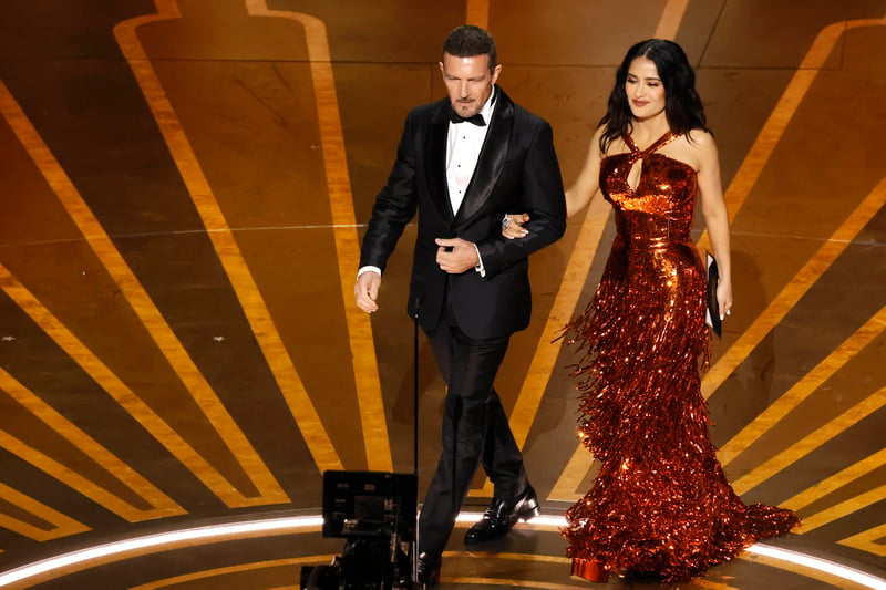 Antonio Banderas and Salma Hayek. Hayek wore a shimmering orange floor length gown with cut out detail while Banderas looked smart in a tuxedo.