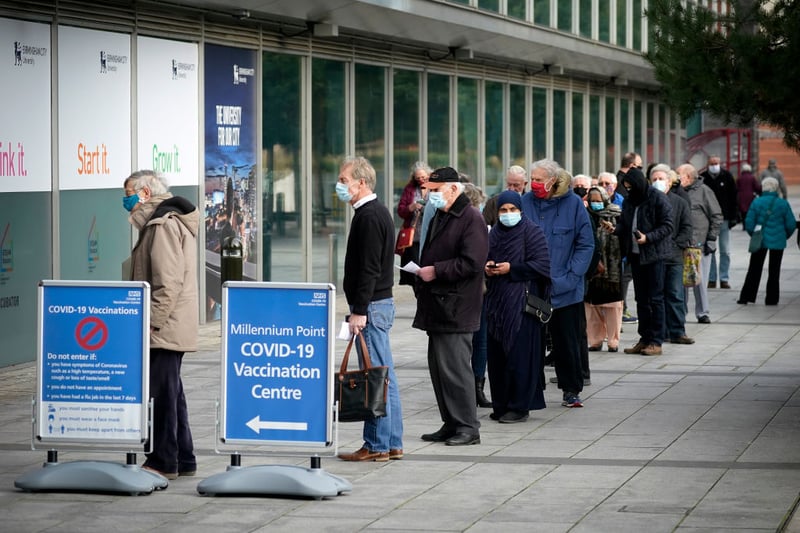 People queue outside the mass NHS Covid-19 vaccine centre that has been set up at the Millennium Point centre in Birmingham on January 11, 2021 in Birmingham, England. The location is one of several mass vaccination centres in England to open to the public this week. The UK aims to vaccinate 15 million people by mid-February. (Photo by Christopher Furlong/Getty Images)