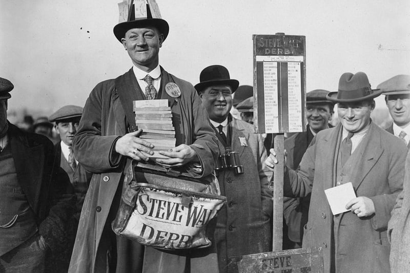 Punters queue up to lay their bets at Steve Wall’s bookmaking stand at Birmingham Race Course on 1st November 1926. The inauguration of a betting tax means that the bookmaker must be well supplied with revenue tickets.  (Photo by Kirby/Topical Press Agency/Getty Images)