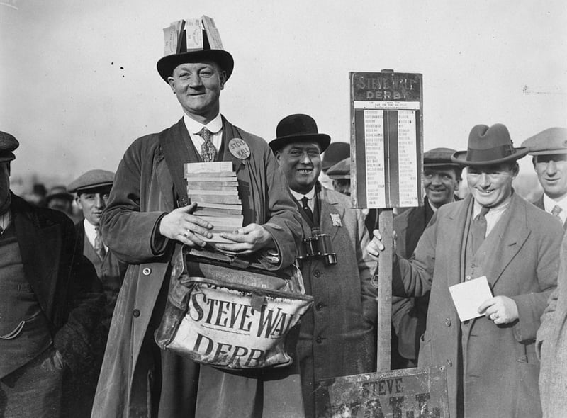 Punters queue up to lay their bets at Steve Wall’s bookmaking stand at Birmingham Race Course on 1st November 1926. The inauguration of a betting tax means that the bookmaker must be well supplied with revenue tickets.  (Photo by Kirby/Topical Press Agency/Getty Images)