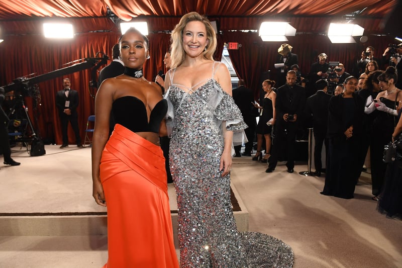 Janelle Monae and Kate Hudson. Monae wore a Vera Wang gown with a pop of orange colour and a black bra. Hudson wore a sequined silver gown.