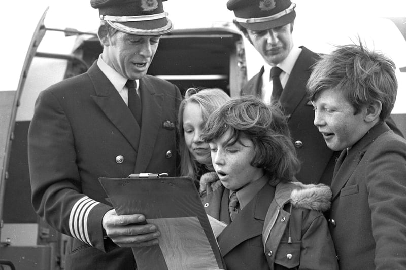 Children look at the flight plan with pilot Captain D K Street and First Officer R. McAulay at Manchester airport for a round Britain flight on a BAC Super 1-11 jet