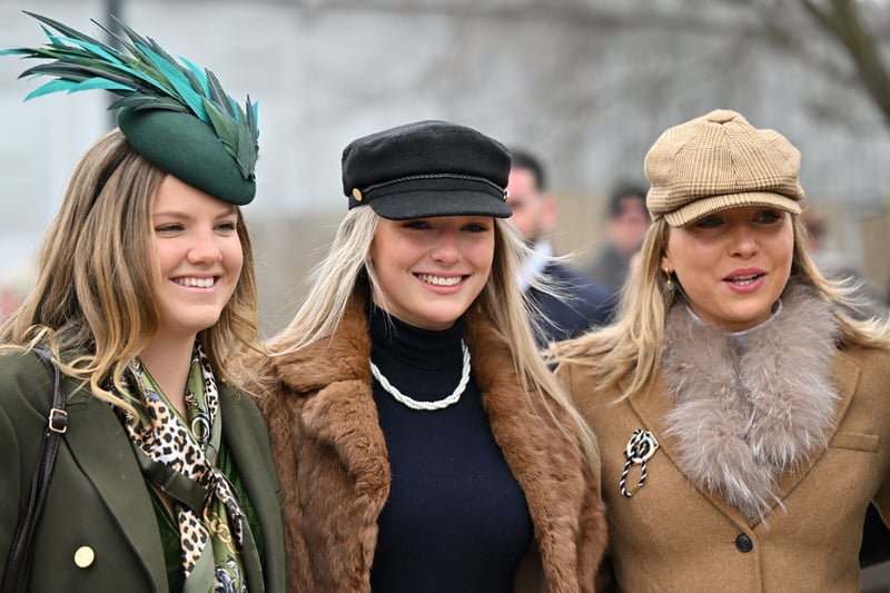 Racegoers pose as they arrive on the second day of the Cheltenham Festival at Cheltenham Racecourse