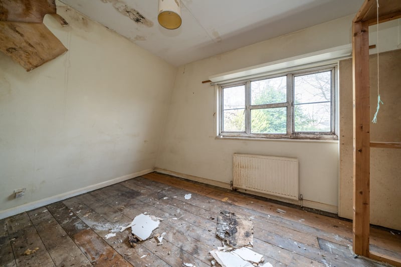 A bedroom with damaged ceiling
