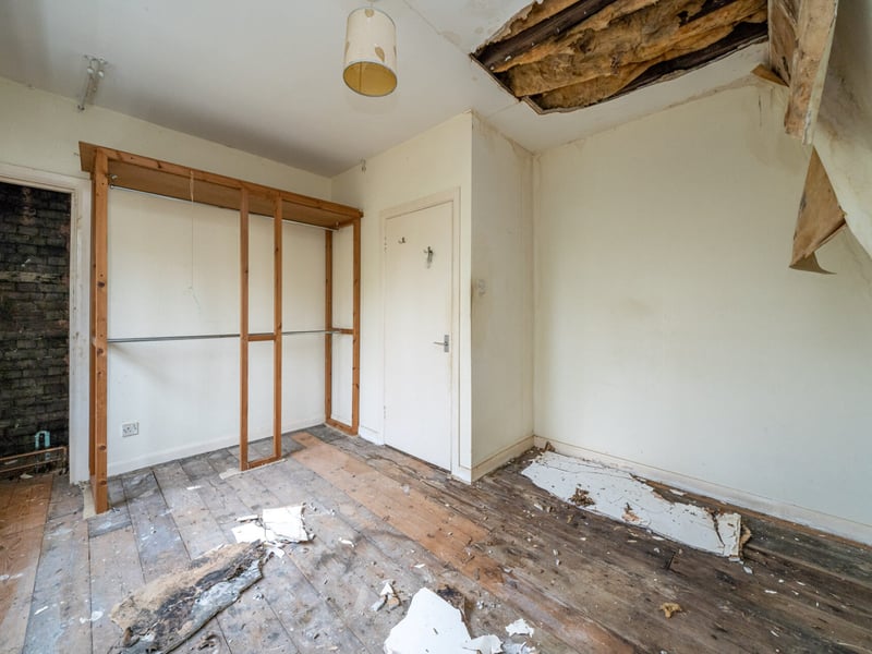 Bedroom with damaged ceiling