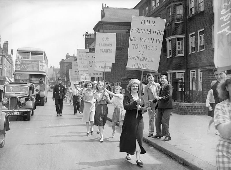 1938: Tenants from Quinns Buildings in Bethnal Green, London, march through the streets carrying banners during a rent strike, protesting over housing conditions.  (Photo by London Express/Getty Images)