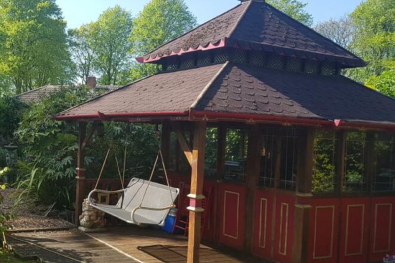 The summer house features a swing seat.