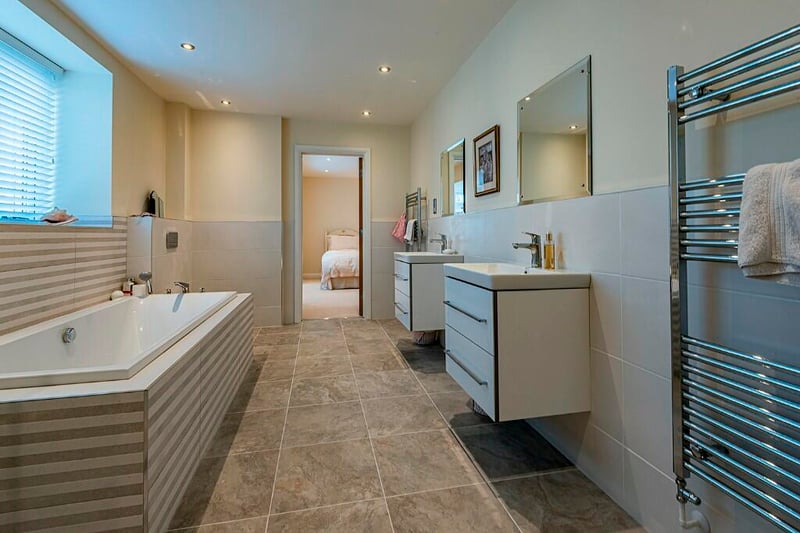 En suite with bathtub and His and Hers.