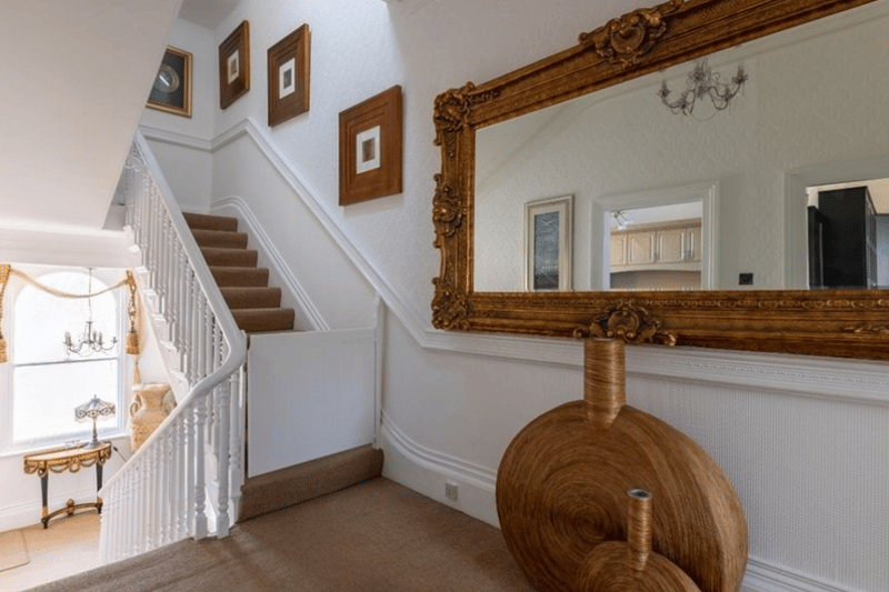 A stair case pictured here with a grand mirror