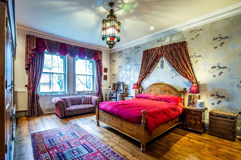 This bedroom features characterful curtains and red bedding
