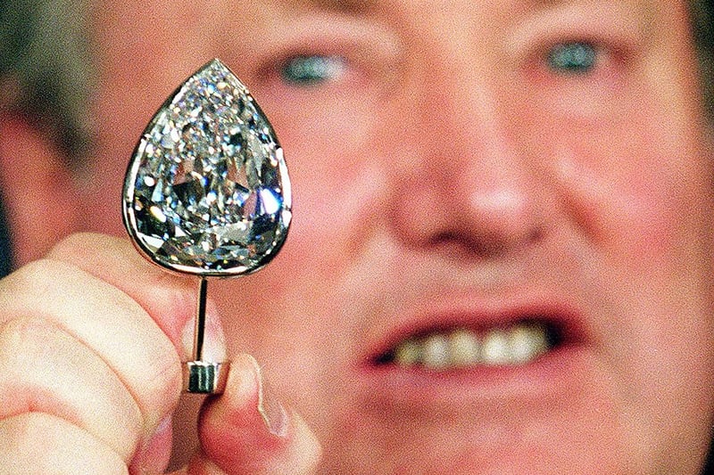 De Beers unveils the world’s biggest pear-shaped diamond, Millennium Star, in Tokyo in October 1999.  The 203-carat diamond was exhibited for the public to celebrate the year 2000 from January 1 at the Millennium Dome. It was also one of the targets of an attempted heist. (Photo by Toru Yamanaka/AFP via Getty Images)