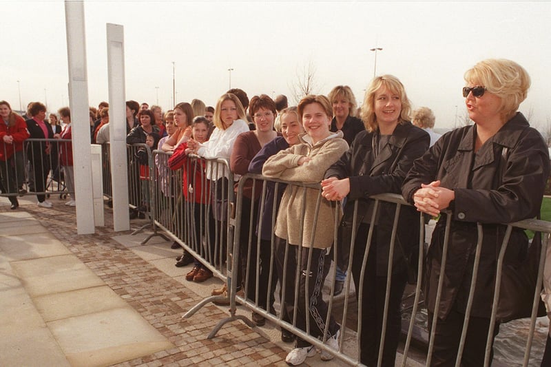 People line along the metal railings as they wait to go inside The Mall on its opening day