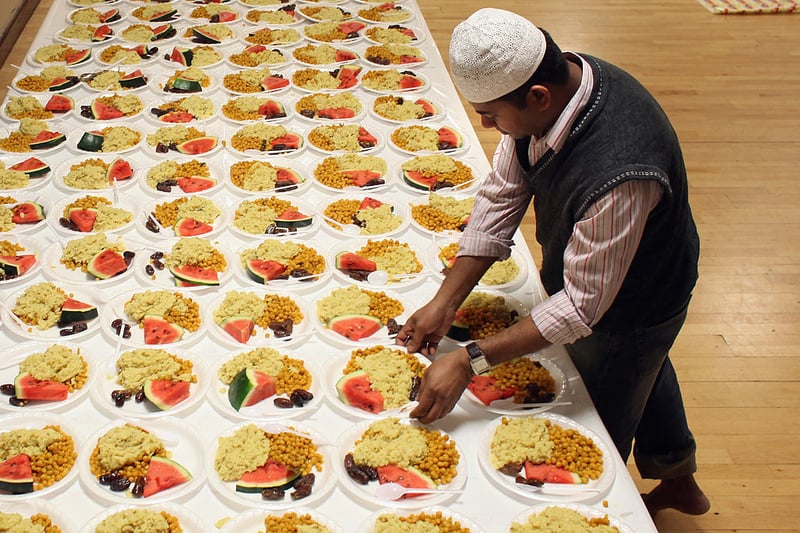 Muslim men eat during Iftar, the evening meal in the Muslim holy month of Ramadan at the London Muslim Centre on August 18, 2010 in London (Photo by Dan Kitwood/Getty Images)