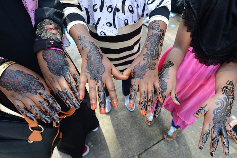 Young Muslim girls show their hands decorated with henna after attending prayers on Eid Al-Fitr at the Regent's Park Mosque in London on August 19, 2012.