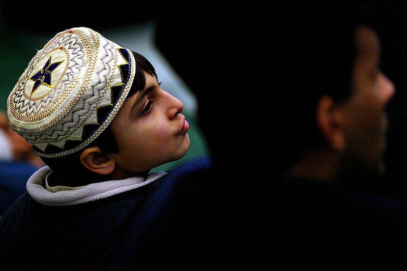 A young worshipper listens to the Eid Al-Fitr prayer of the leader of the worldwide Ahmadiyya Community Hadhrat Mirza Masroor Ahmad at the Baitful Futuh Mosque in London 26 November 2003.