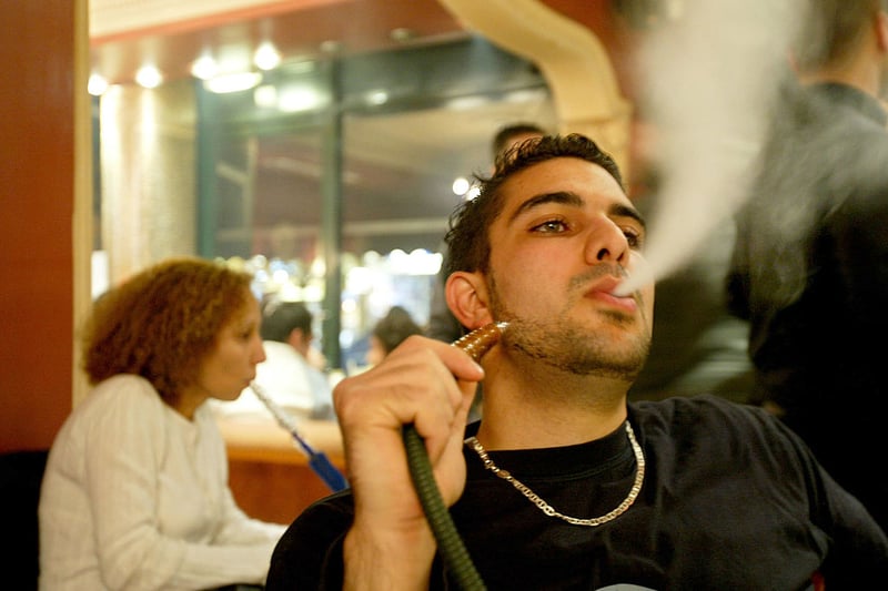 A Muslim man smokes out of a water pipe in a coffee shop after a second day of fasting for Ramadan October 16, 2004 in London (Photo by Abid Katib/Getty Images)