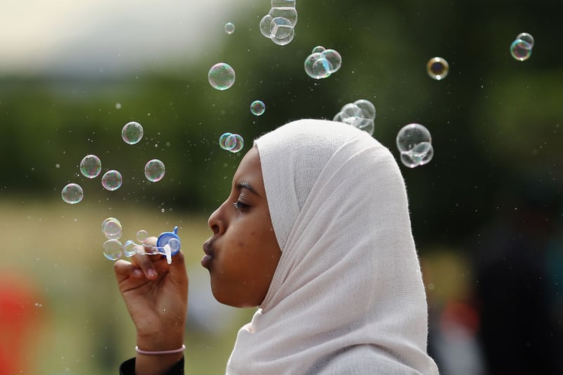 A girl blows bubbles during an Eid celebration in Burgess Park on July 28, 2014 in London (Photo by Dan Kitwood/Getty Images)