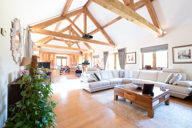 The large living room area with exposed wood beams