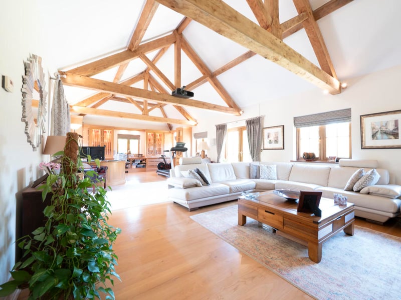 The large living room area with exposed wood beams