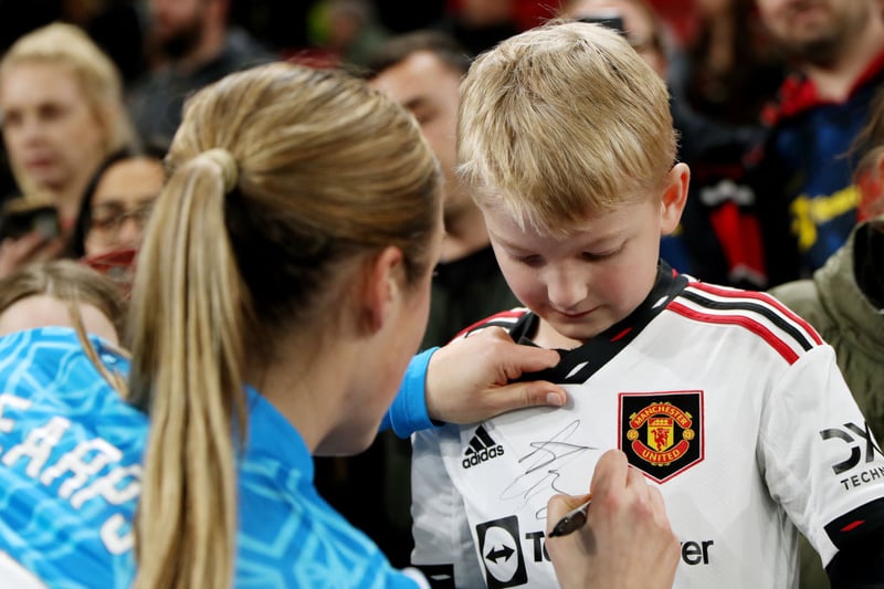Man Utd goalkeeper Mary Earps signs a young fans shirt following the victory at Old Trafford.