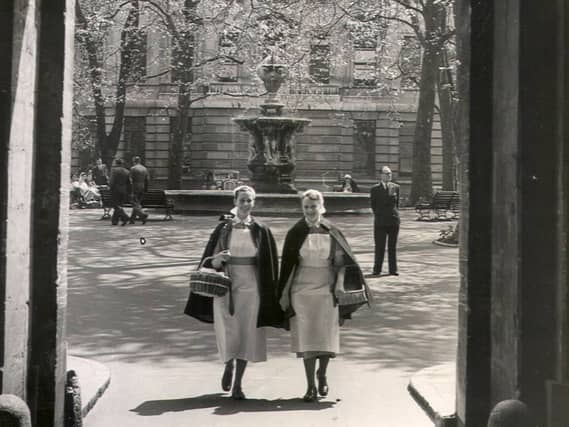 Two nurses walking through the archway of the North Wing, May 22 1954