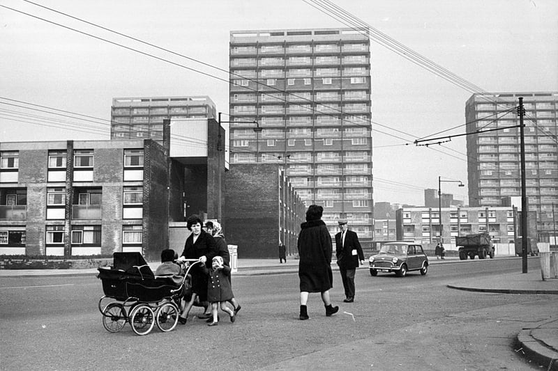A child helps their mum push a pram through the freshly refurbished Gorbals (Photo by Albert McCabe/Express/Getty Images)