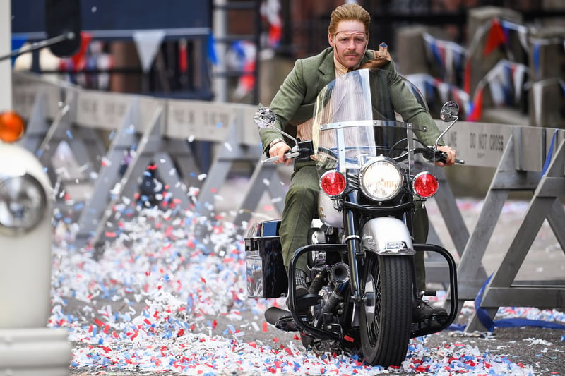A stunt-double with a fake face rides a motorbike for an action scene, presumably the thick black line will be edited out with movie-magic (Photo by Jeff J Mitchell/Getty Images)