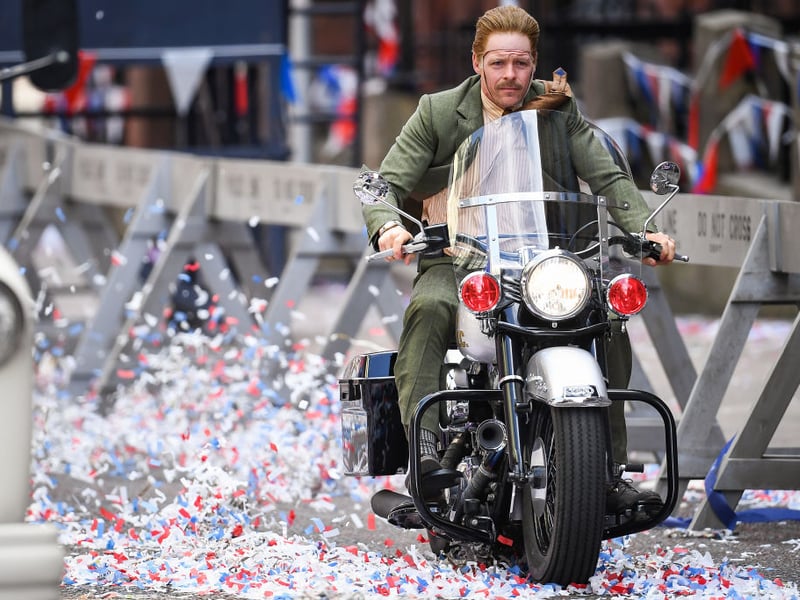 A stunt-double with a fake face rides a motorbike for an action scene, presumably the thick black line will be edited out with movie-magic (Photo by Jeff J Mitchell/Getty Images)
