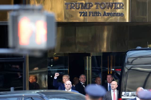 Trump held his hand up in a fist to waiting journalists, supporters, and protestors as he departed Trump Tower (Photo by Scott Olson/Getty Images)