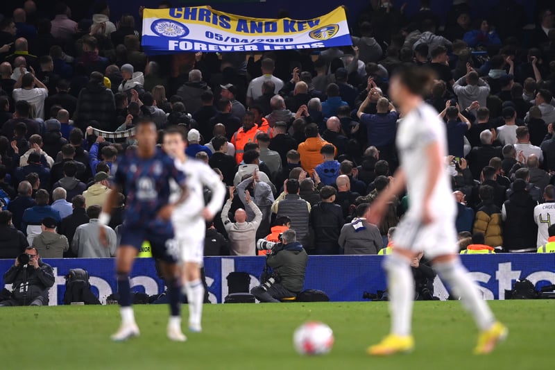 Leeds United fans hold up a banner and turn their backs to the play in the 23rd minute