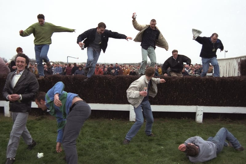 The crowd sieze the opportunity to jump the famous fences at Aintree due to the evacuation of the stands, caused by the IRA bomb scare which postponed The Grand National.