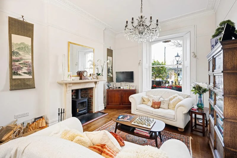 The living room with its characterful high ceilings and log burner would be a cosy place to retreat to in the evenings.