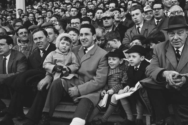 Spurs legend Dave Mackay watches from the sidelines with his children on February 2, 1964, as his teammates take on Chelsea - due to a broken leg. (Photo by Evening Standard/Hulton Archive/Getty Images)