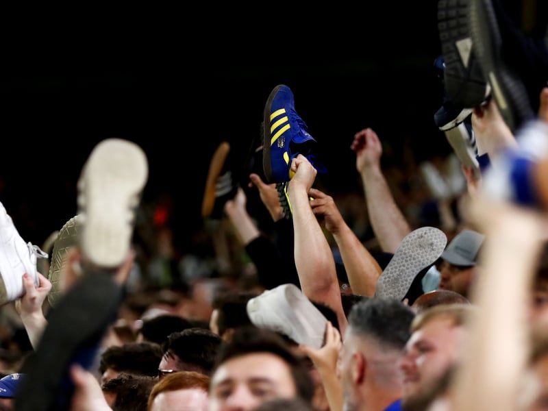 Leeds United fans show their support by taking their shoes off.