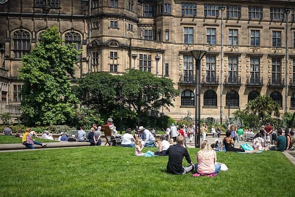 People sit on the grass on a warm day at the city center of Sheffield. (Photo by Giannis Alexopoulos/NurPhoto via Getty Images)