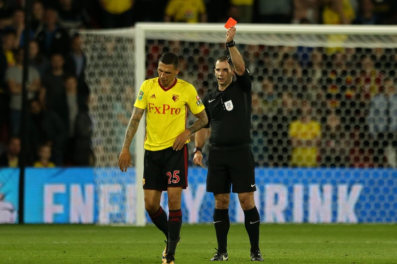 The referee shows Jose Holebas the red card. 